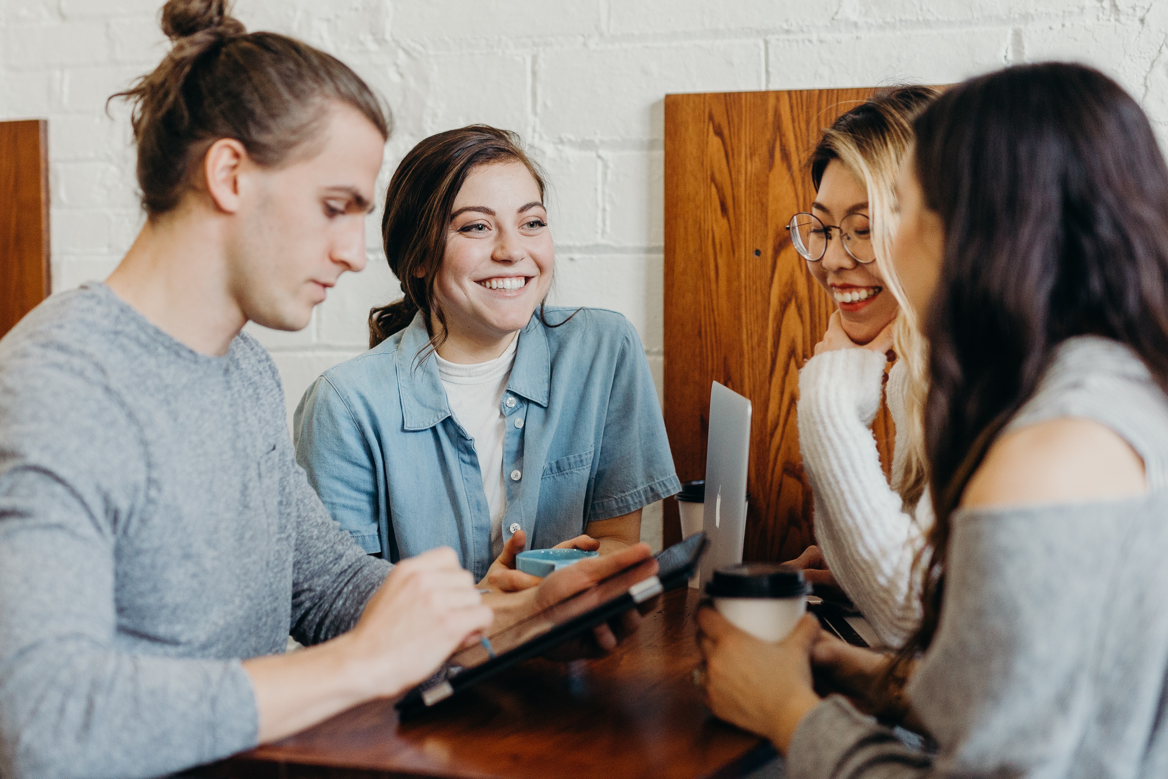 people sitting at a table chatting. Photo by Brooke Cagle on Unsplash